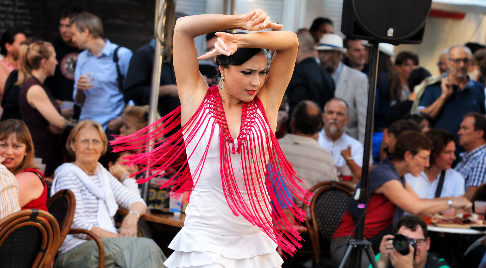 Danseuse de flamenco en robe blanche et châle rose se produisant devant le public