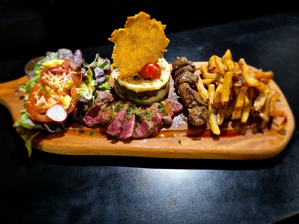 Planche de viandes accompagnées de frites et de salade composée